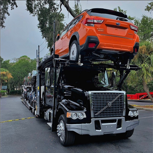 Auto transport carrier hauling a car on top load
